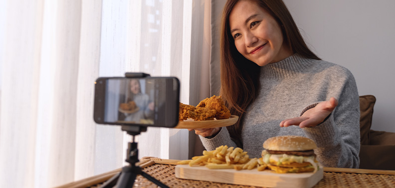 youtuber gravando vídeo sobre comida que recebeu por parceria com um restaurante