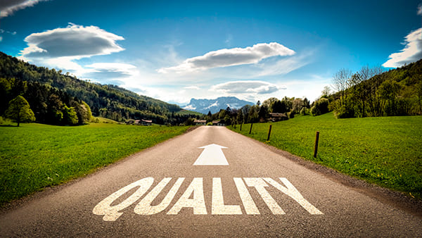 Estrada com a palavra "qualidade" em inglês e uma flecha apotando para frente, apontando a direção de e-mails de qualidade.
