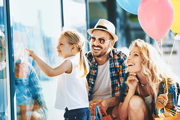 Família feliz olhando uma vitrine.