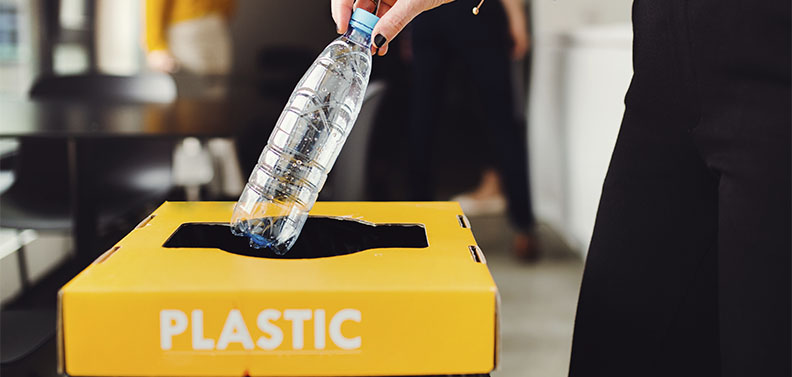 mulher jogando garrafa no lixo de plástico na empresa